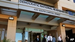 Orang-orang berdiri di depan kantor pusat Komisi Nasional Partai Demokrat (DNC) di Washington, D.C. (Foto: dok.)