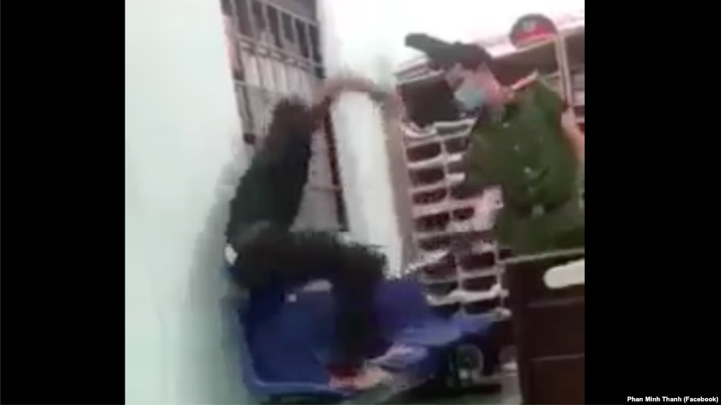 Hình ảnh trích xuất từ video lan truyền trên mạng xã hội về một nhân viên công an phường ở Quảng Nam dí dùi cui điện vào một đối tượng đang bị còng 1 tay vào song cửa sổ trong lúc hỏi cung hôm 8/9.