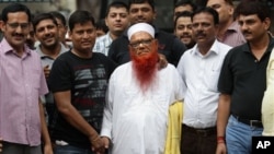 Plaincloth Indian policemen surround Abdul Karim Tunda, center in white cap, New Delhi, Aug. 17, 2013.