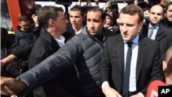 Alexandre Benalla, center, an aide to President Emmanuel Macron, left, charged with security, has been seen in a video wearing a police helmet and beating up a student protester in May, reigning criticism on Macron notably due to the light punishment - a two-week suspension. 