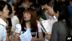 FILE - Chinese job seekers visit a job fair held at the China International Exhibition Center in Beijing.