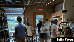 Patrons at a coffee shop in the trendy NoDa neighborhood of Charlotte, NC, wear masks. (Salim Fayeq/VOA)