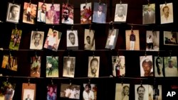 FILE - Family photographs of some of those who died hang in a display in the Kigali Genocide Memorial Centre in Kigali, Rwanda, April 2014. Officials said Rwandan Ladislas Ntaganzwa was arrested by Interpol agents in Congo, Dec. 7, 2015.