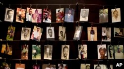 FILE - Family photographs of some of those who died hang in a display in the Kigali Genocide Memorial Centre in Kigali, Rwanda, April 2014. 