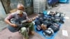 Seorang penjaja dagangan bermain gitar sambil menunggu pembeli di pinggir jalan di tengah pandemi Covid-19 di Jakarta, 21 April 2020. 