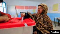 A Tunisian woman casts her ballot in the capital Tunis, Dec. 21, 2014. 