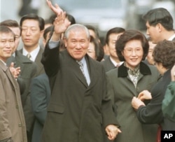 FILE - A smiling former South Korean President Roh Tae-woo, with his wife Kim Ok-sook standing beside him, waves to his supporters and neighbors upon arrivial at his home after he was released from the Seoul prison in a vspecial amnesty, Dec. 22, 1997.