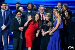 ماییم بیالیک (لباس قرمز) در کنار دیگر دست اندرکاران سریال بیگ بنگ در هنگام دریافت «جایزه منتخب مردم» در ژانویه ۲۰۱۷
