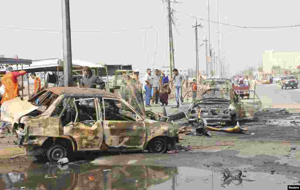 Residents gather at the site of a bomb attack in Basra, Iraq, May 20, 2013. 