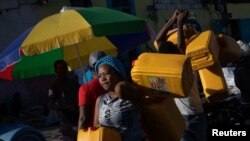 Locals carry containers, used for oil and gasoline, during fuel shortages in Port-au-Prince, Haiti, Oct. 24, 2021. 