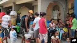 태풍 ‘하구핏’이 필리핀에 접근 중인 가운데, 4일 타클로반 시민들이 구호소로 대피하고 있다.
