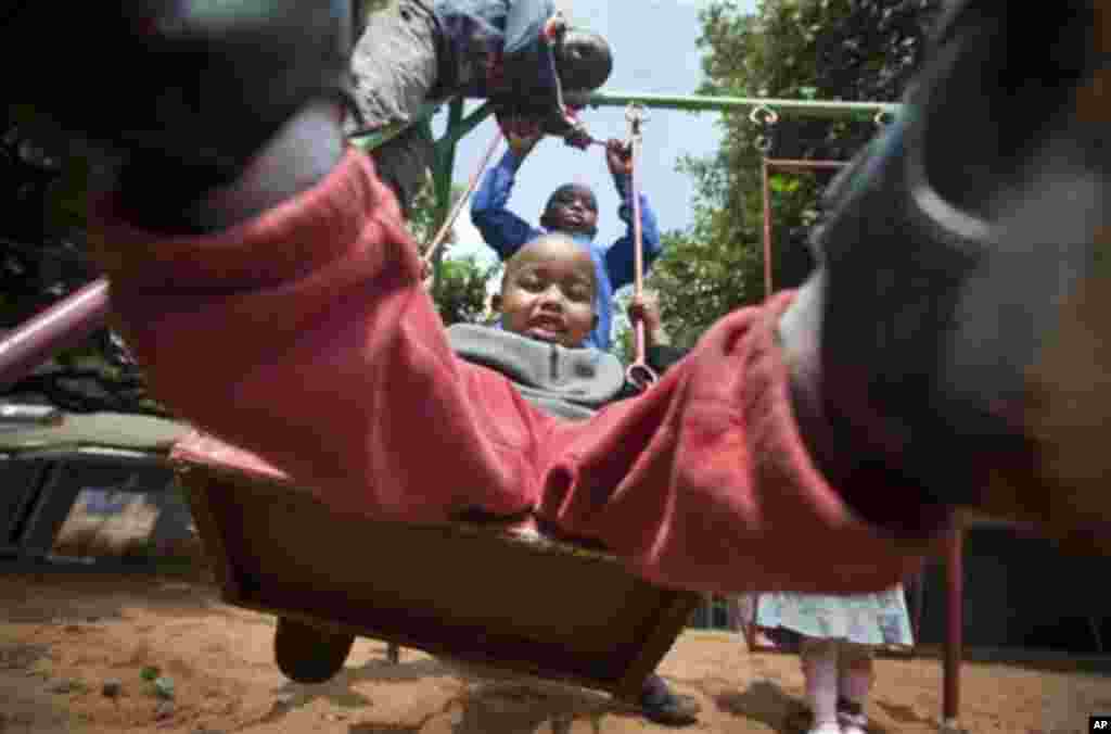 Children play on the swings during playtime at the Nyumbani Children's Home for children with HIV, in Karen on the outskirts of Nairobi, Kenya Wednesday, Nov. 30, 2011. The orphanage, which is heavily reliant on foreign donations, cares for over 100 child