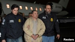 FILE - Mexico's top drug lord Joaquin "El Chapo" Guzman is escorted as he arrives at Long Island MacArthur airport in New York, Jan. 19, 2017, following his extradition from Mexico.