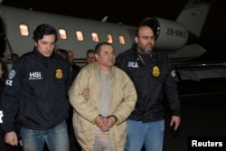 FILE - Mexico's top drug lord Joaquin "El Chapo" Guzman is escorted as he arrives at Long Island MacArthur airport in New York, Jan. 19, 2017, following his extradition from Mexico.