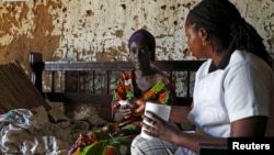 A Service Yezu Mwiza (SYM- Good Jesus) nurse hands medication to an HIV-AIDS patient, who is also suffering from malaria, at her home in Gatumba, outside Bujumbura, April 19, 2013.