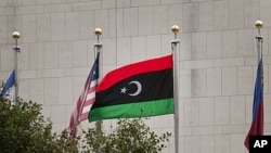 The pre-Gadhafi Libyan flag flies in front of the United Nations headquarters during the 66th session of the General Assembly at United Nations headquarters in New York, Sept. 20, 2011.