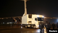 Para petugas di bandara Pulkovo, St.Petersburg, Rusia, Selasa (2/11) bersiap untuk mengeluarkan mayat korban pesawat Metrojet yang jatuh di Mesir hari Sabtu lalu.