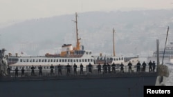 U.S. sailors stand aboard the USS Ross as it leaves from the port in Istanbul, Nov. 13, 2014.