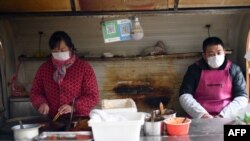 2020年1月26日，北京一家餐馆员工戴口罩进行食品操作。