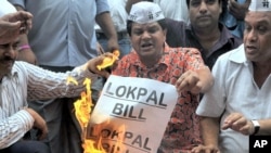 Anti-corruption activists burn symbolic copies of the Lokpal Bill (anti-corruption bill) during a protest to denounce the proposal in its current form in Mumbai on August 4, 2011.