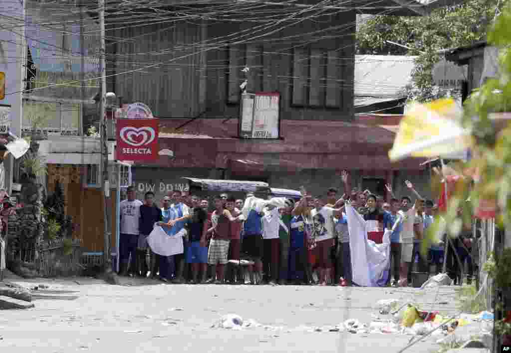 Residents believed to be hostages wave white cloths as they shout at troops to stop their operation in the continuing standoff with Muslim rebels, Zamboanga, Philippines, Sept.11, 2013.