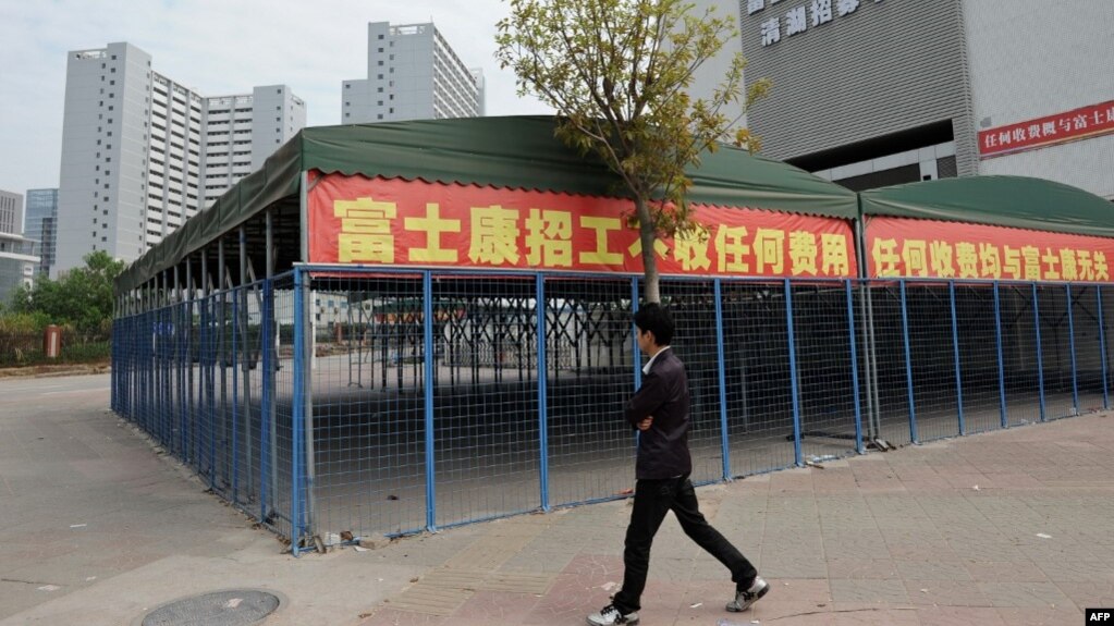 This picture taken on February 22, 2013 shows a man walking past empty tents in a Foxconn recruitment center in Shenzhen, south China's Guangdong province. 