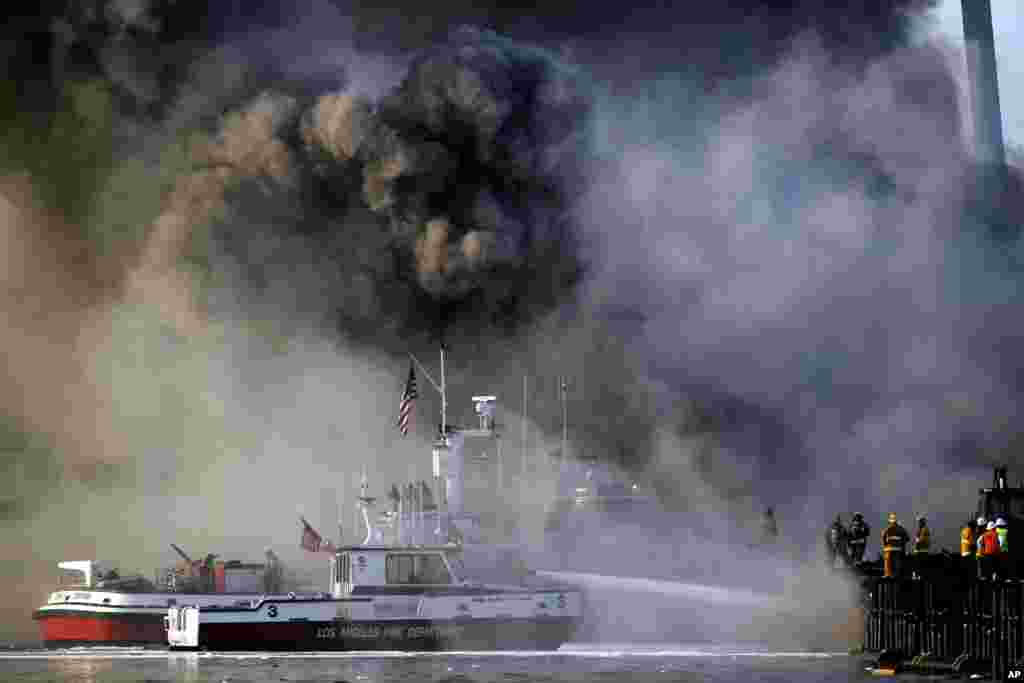 Los Angeles firefighters watch as smoke from a dock fire continues to rise at the Port of Los Angeles in the Wilmington section of Los Angeles, California, USA, Sept. 23, 2014.