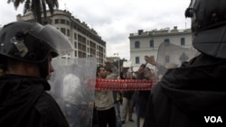 Demonstran berhadap-hadapan dengan polisi anti-huru-hara di Tunis, Tunisia.