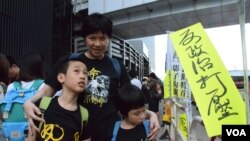 香港市民劉太太帶同一對9歲及7歲的子女參與雨傘運動一周年活動。 (美國之音特約記者湯惠芸照)