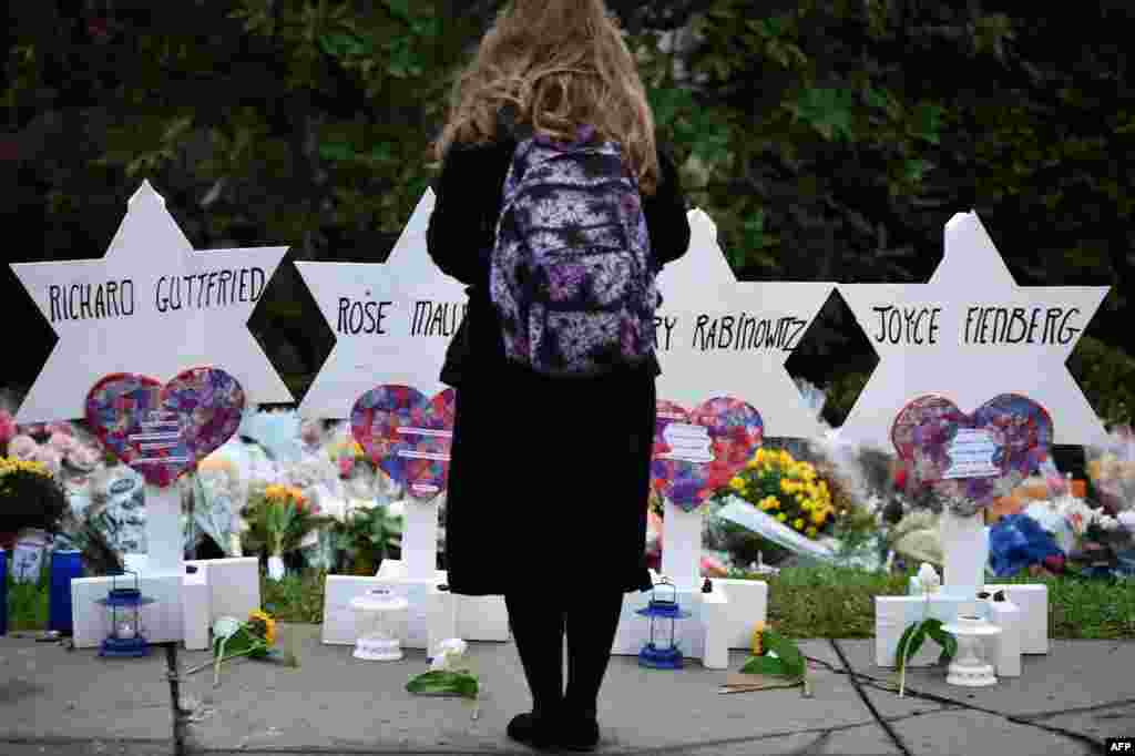 미국 피츠버그시의 &#39;생명의 나무&#39; 유대교회당에서 총기 사건이 발생해 11명이 숨진 가운데, 여성이 사고현장 밖에 마련된 임시 추모소에서 희생자들을 애도하고 있다.