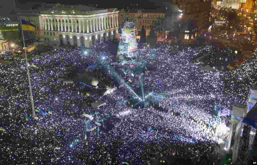 Pro-European Union activists hold lights as they sing the Ukrainian national anthem, celebrating the New Year in Kyiv, Ukraine, Jan. 1, 2014. 