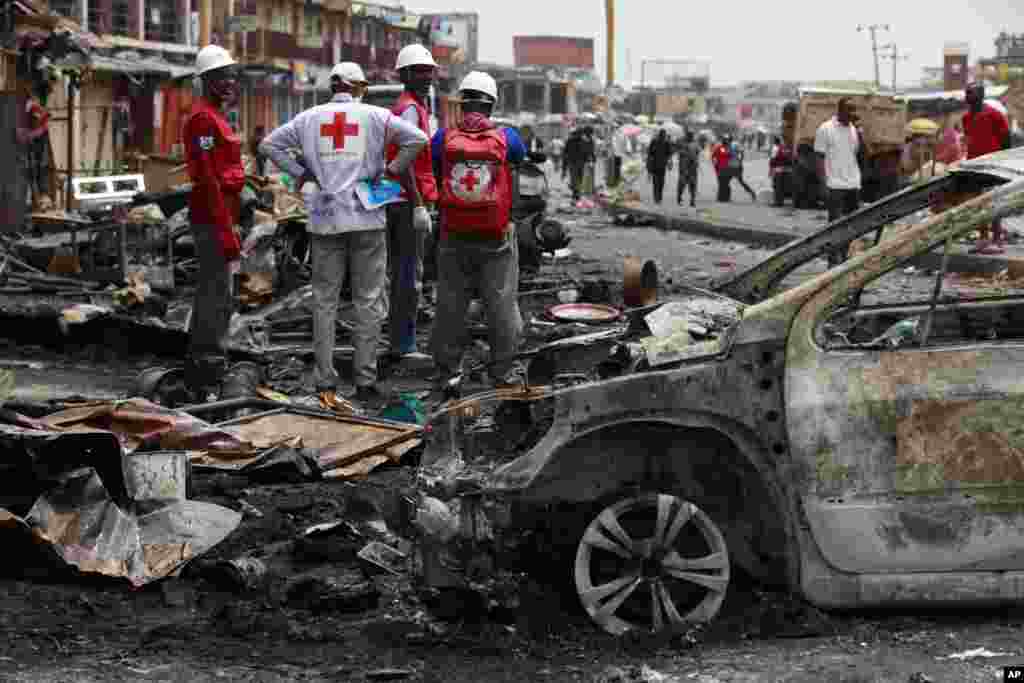 Red Cross personnel search for remains at the site of a car bomb in Jos, Nigeria, May 21, 2014. 