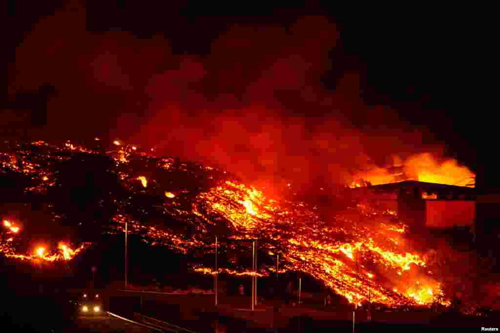 Lava burns buildings following the eruption of the Cumbre Vieja volcano in Tacande, Spain, Oct. 9, 2021.