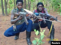 FILE - Fighters loyal to the Lord's Resistance Army pose with their rifles inside the forest near River Mbou in the Central African Republic in this handout picture dated April 4, 2012.