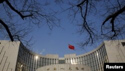 A Chinese national flag flies at the headquarters of the People's Bank of China, the country's central bank, in Beijing, China, Jan. 19, 2016. 