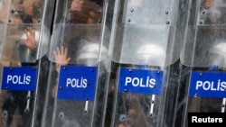 Turkish riot police use their shields to protect themselves as they clash with protesters in central Istanbul, July 8, 2013. 