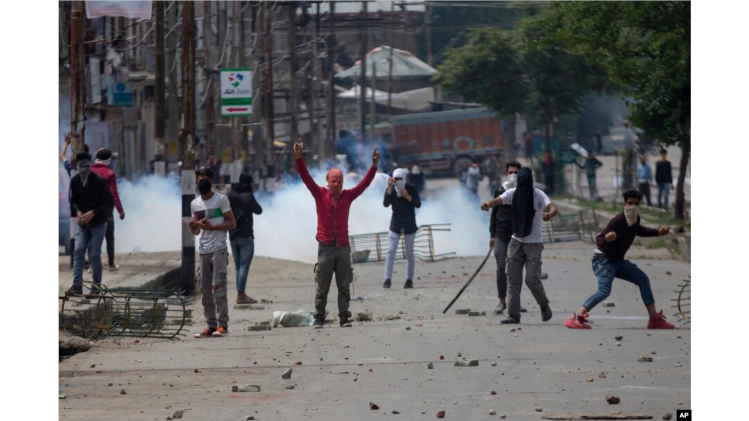 FILE - Kashmiri protesters throw rocks and bricks at Indian paramilitary soldiers near the site of a gunbattle in Srinagar, Indian-controlled Kashmir, May 5, 2018.