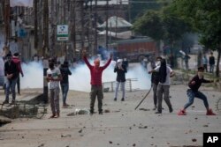 FILE - Kashmiri protesters throw rocks and bricks at Indian paramilitary soldiers near the site of a gunbattle in Srinagar, Indian-controlled Kashmir, May 5, 2018.