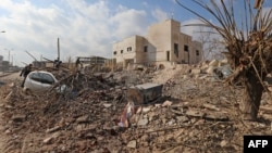FILE - Destruction is seen around the Udai hospital following airstrikes on the town of Saraqeb in Syria's northwestern province of Idlib, Jan. 29, 2018. Syrian troops had been advancing on Idlib as part of a fierce offensive launched in late December with Russian backing.
