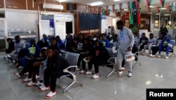 FILE- Guinean migrants wait at the airport before being deported to Guinea, in Misrata, Libya, Dec. 27, 2017.