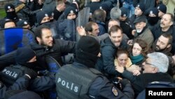 Demonstrators scuffle with riot police during a protest against the detention of the head of the Turkish Medical Association and other leaders of the doctors' union, in Ankara, Turkey, Jan. 30, 2018.