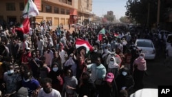 People march during a protest to denounce the October military coup, in Khartoum, Sudan, Dec. 30, 2021.