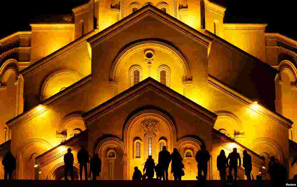 People walk in front of the Holy Trinity cathedral during a midnight Christmas service in Tbilisi, Georgia.