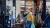 Une femme et un homme portant des masques faciaux passent devant un magasin à Leipzig, dans l'est de l'Allemagne, le 20 avril 2020, au milieu de la pandémie du nouveau coronavirus COVID-19. (Photo par Tobias SCHWARZ / AFP)