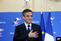 FILE - Francois Fillon puts his hand on his heart after delivering a speech following the conservative presidential primary, in Paris, France, Nov. 27, 2016.