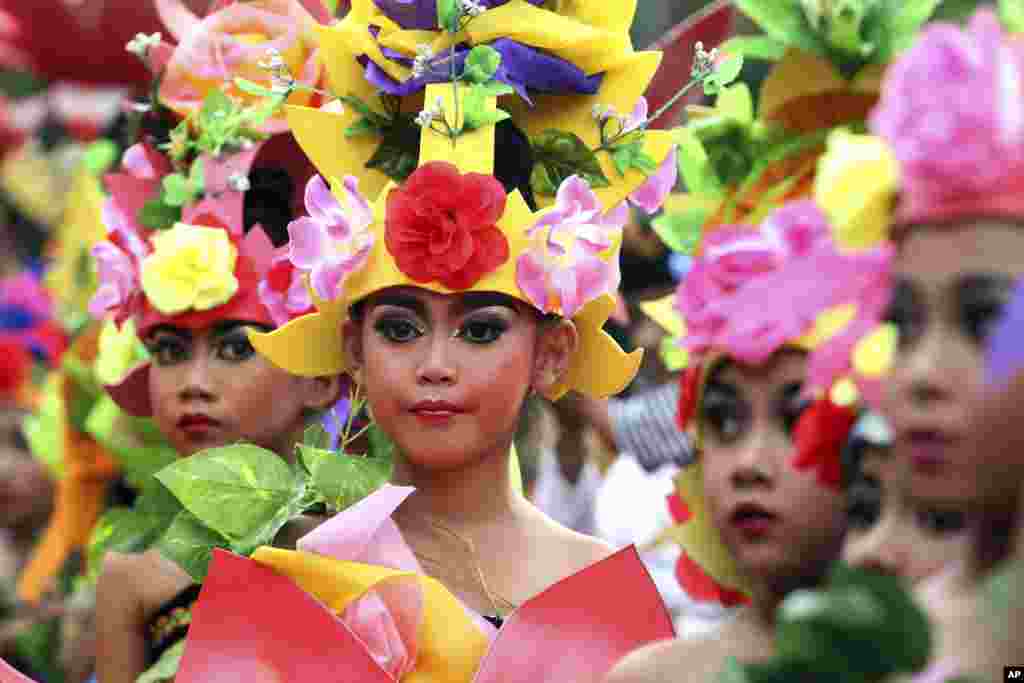 جزیرہ بالی، انڈونیشیا میں بچے 2015 کا آخری سورج غروب ہونے پر مختلف لباس میں ملبوس ہو کر پریڈ میں شامل ہیں