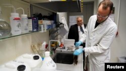 Tartu University's professor Enn Lust and student Patrick Teppor work on carbon-based batteries using peat, in Tartu, Estonia, on September 30, 2021. (REUTERS/Janis Laizans)