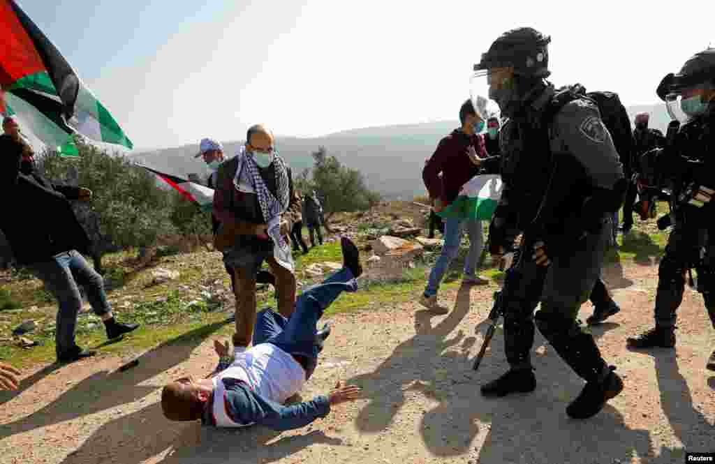 A Palestinian demonstrator falls on the ground after being knocked down by Israeli forces during a protest against Jewish settlements in Salfit in the Israeli-occupied West Bank.