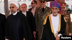FILE - Oman's Sultan Qaboos bin Said (R) walks with Iran's President Hassan Rouhani upon Rouhani's arrival in Muscat, Oman, March 12, 2014.