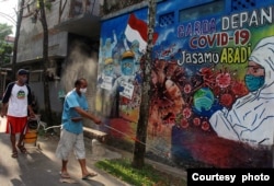 Warga menyemprotkan cairan disinfektan untuk mencegah penyebaran COVID-19 di salah satu area lingkungan di Tangerang, pada 15 Mei 2020. (Foto: Antara Foto/Muhammad Iqbal via Reuters)